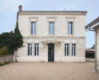 a large white brick house with a black door at Résidence Pompidou Libourne in Libourne