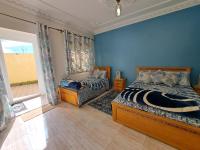 a bedroom with blue walls and a bed and a window at Diafa Stay in Tangier