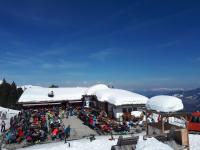 Una multitud de personas sentadas afuera de un albergue de esquí. en Schwaiger Alpen-Ferienwohnung auf 1800m, en Kaltenbach