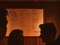 a group of people standing in front of a menu at The 1852 Hotel - Self Check-in in Belfast