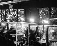 a woman sitting at a table in a restaurant at night at The 1852 Hotel - Self Check-in in Belfast