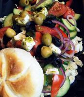 uma salada com azeitonas e vegetais em um prato em Dark Pub Hotelik em Gorlice