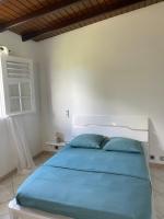 - une chambre avec un grand lit et des oreillers bleus dans l&#39;établissement Villa corail, à Lamentin