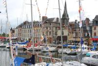a group of boats docked in a harbor with buildings at Lovely cottage in Honfleur center in Honfleur