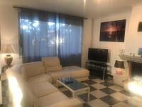 a living room with a white couch and a tv at Villa, avec piscine chauffée in Servian