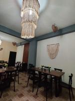 巴耶斯城Hotel Tamtokow的餐厅里有桌椅和吊灯