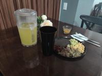 巴耶斯城Hotel Tamtokow的一张桌子,上面放着一杯橙汁和一盘食物