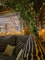 un banco con almohadas y una mesa con luces en Playa de Camariñas, en Camariñas