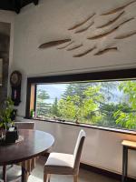 a dining room with a table and a large window at Bridge12th B&amp;B in Yanliau