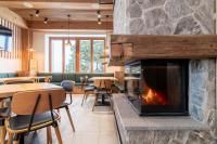 una chimenea en un restaurante con mesas y sillas en Ribniška koča, en Ribnica na Pohorju