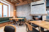 Un restaurante con mesas y sillas de madera y chimenea. en Ribniška koča, en Ribnica na Pohorju