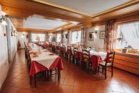 a row of tables in a restaurant with red table cloth at Hotel Edelweiss in Val di Zoldo