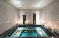 a swimming pool in a building with candles in it at Grand Hôtel Du Palais Royal in Paris