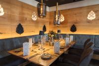 a long table in a restaurant with chairs and lights at Das Metzgerbräu - Hotel & Brauereigasthof in Hohenwart