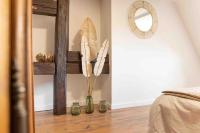 Habitación con espejo y jarrón con plumas en Les Lionceaux, 120m2 à Colmar, place de parking gratuite, en Colmar