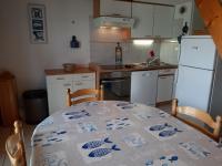 a kitchen with a table and a white refrigerator at Maison Jard-sur-Mer, 3 pièces, 5 personnes - FR-1-485-78 in Jard-sur-Mer