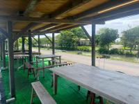 a group of picnic tables and benches under a pavilion at Dongshan River Resort Farm in Wujie