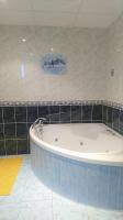 a bath tub in a bathroom with black tiles at Au Coeur du Jura, Logement au calme in Champagnole