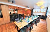 a restaurant with long tables and chairs and a bar at Triftblick in Gadmen