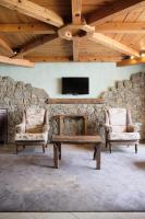 ein Wohnzimmer mit 2 Stühlen und einer Steinmauer in der Unterkunft Apartaments Els Llacs in Bordes d´Envalira 