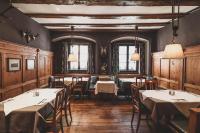 a dining room with tables and chairs and windows at Boutiquehotel Weisses Rössl in Innsbruck