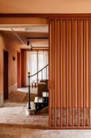 une pièce aux murs orange et un couloir avec un escalier dans l'établissement CASA Y FONDA 1888, à Alcalá de Henares