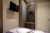 a bedroom with a bed with a television and a closet at Alle Guglie Boutique Hotel in Venice