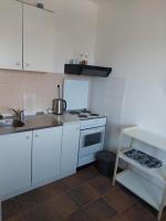 a kitchen with white cabinets and a stove top oven at Apartmani Ivušić in Dubrava