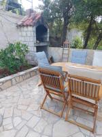 a patio with a table and two chairs and a fireplace at Apartmani Ivušić in Dubrava