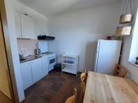 a kitchen with a table and a white refrigerator at Apartmani Ivušić in Dubrava