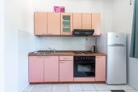 a kitchen with pink cabinets and a refrigerator at Apartmani Ivušić in Dubrava