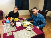 um homem e uma mulher sentados à mesa com comida em Hotel Happy Land em Chitwan