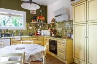 a kitchen with yellow cabinets and a table at Maison du Baou - Welkeys in Toulon