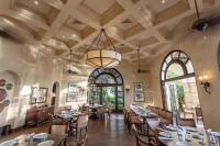 a dining room with tables and chairs and a chandelier at Rancho Santana in El Limón