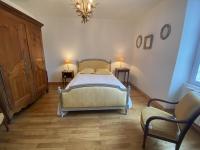 a bedroom with a bed and two chairs and a chandelier at Maison Fouras, 6 pièces, 8 personnes - FR-1-709-39 in Fouras