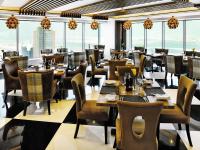 a restaurant with tables and chairs and large windows at The Domain Bahrain Hotel and Spa - Adults Friendly 16 Years Plus in Manama