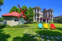 a house with colorful chairs and a windmill in the yard at 伊莎愛莉溜滑梯親子民宿 in Wujie