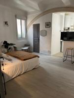 a white bedroom with a bed and a table in it at L&#39;Auberge Espagnole - Bed &amp; Breakfast in Apt