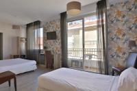 ビアリッツにあるHotel Marbellaのベッド2台とバルコニー付きのホテルの部屋