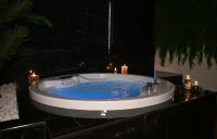 bañera con agua azul en una habitación con velas en Palace Eight - Suites &amp; Spa, en Cosenza