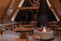 uma sala grande com mesas e uma fogueira em Tawa Refugio del Puelo em Puelo