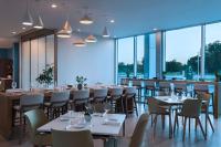 韦科Element Waco的一家有桌椅和大窗户的餐厅