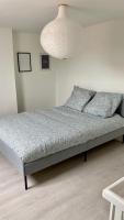 Ce lit se trouve dans une chambre dotée d&#39;un mur blanc. dans l&#39;établissement Maisonette Tran, à Lille