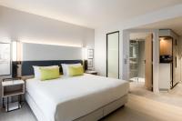 Un dormitorio con una gran cama blanca con almohadas amarillas. en Courtyard by Marriott Paris Creteil, en Créteil