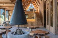 uma sala com mesas de madeira e um grande abajur preto em Tawa Refugio del Puelo em Puelo