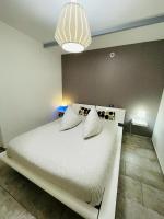 a bedroom with a large white bed with pillows at Flat on 2 floors near stade de france in Aubervilliers