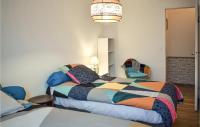 a bedroom with a bed with a colorful comforter at Awesome Home In Paimpol With Kitchen in Paimpol