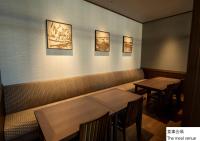 due tavoli e sedie in un ristorante con foto sul muro di La Vista Hakodate Bay Annex a Hakodate