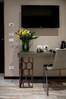 a vase of yellow flowers on a table with a television at Alle Guglie Boutique Hotel in Venice