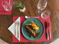 Una mesa con un plato de comida con maíz y verduras. en Logis Hôtels - Hôtel Restaurant Domaine Les Falaises, en Martel